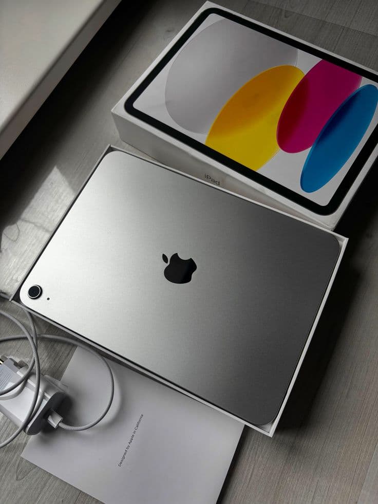 An iPad resting on a MacBook, both in silver